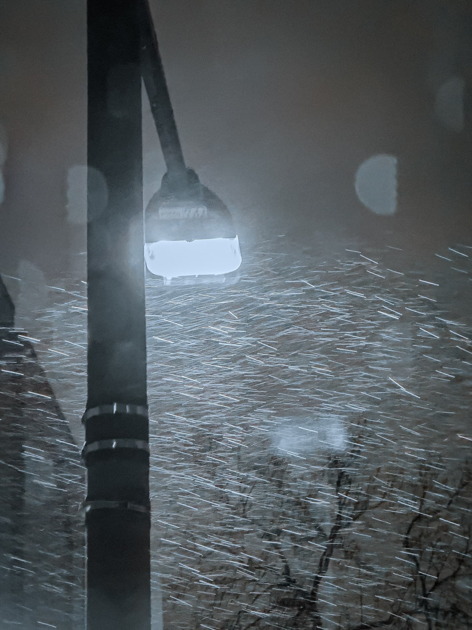 A glowing light post against a dark evening sky