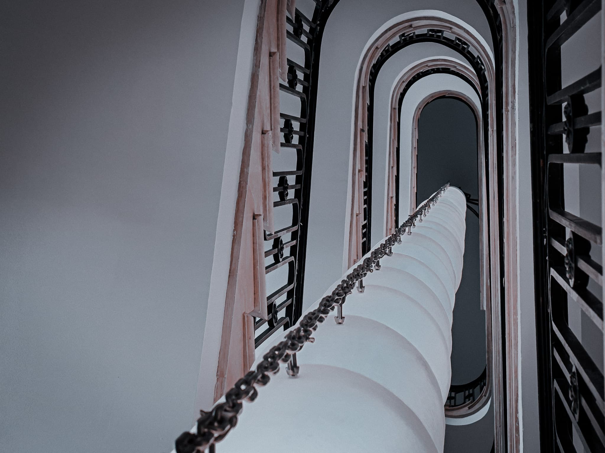 Looking down a spiral staircase through a geometric tunnel